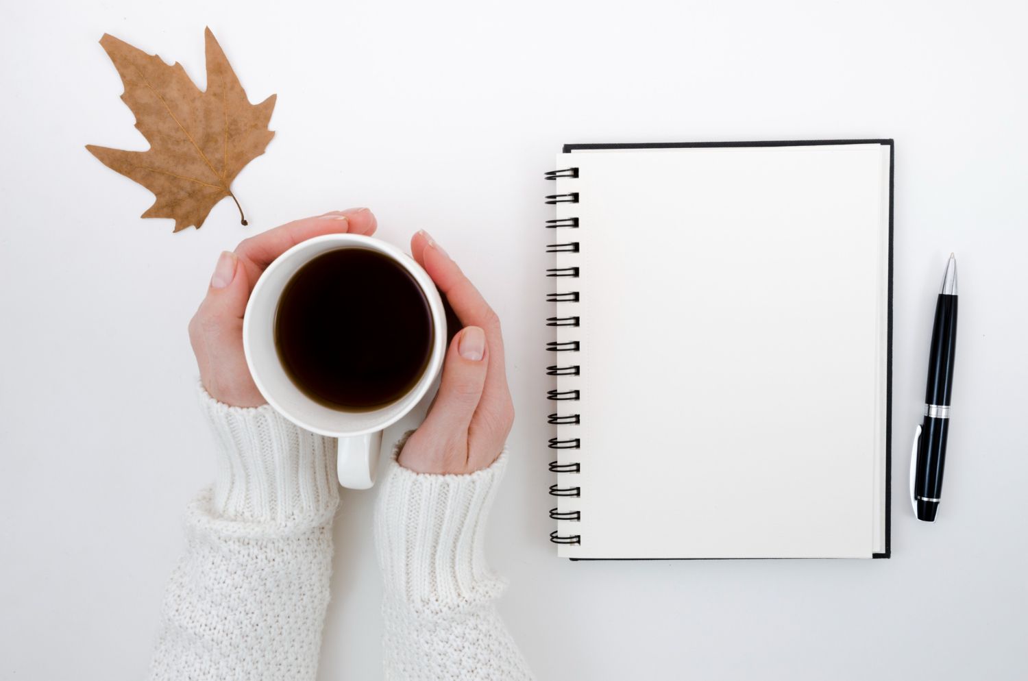 Coffee and notebook on a clean desk